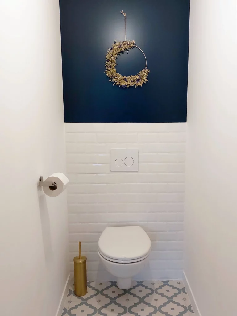 WC avec soubassement blanc et mur bleu avec carrelage à motifs pensé par une architecte d'intérieur du 92