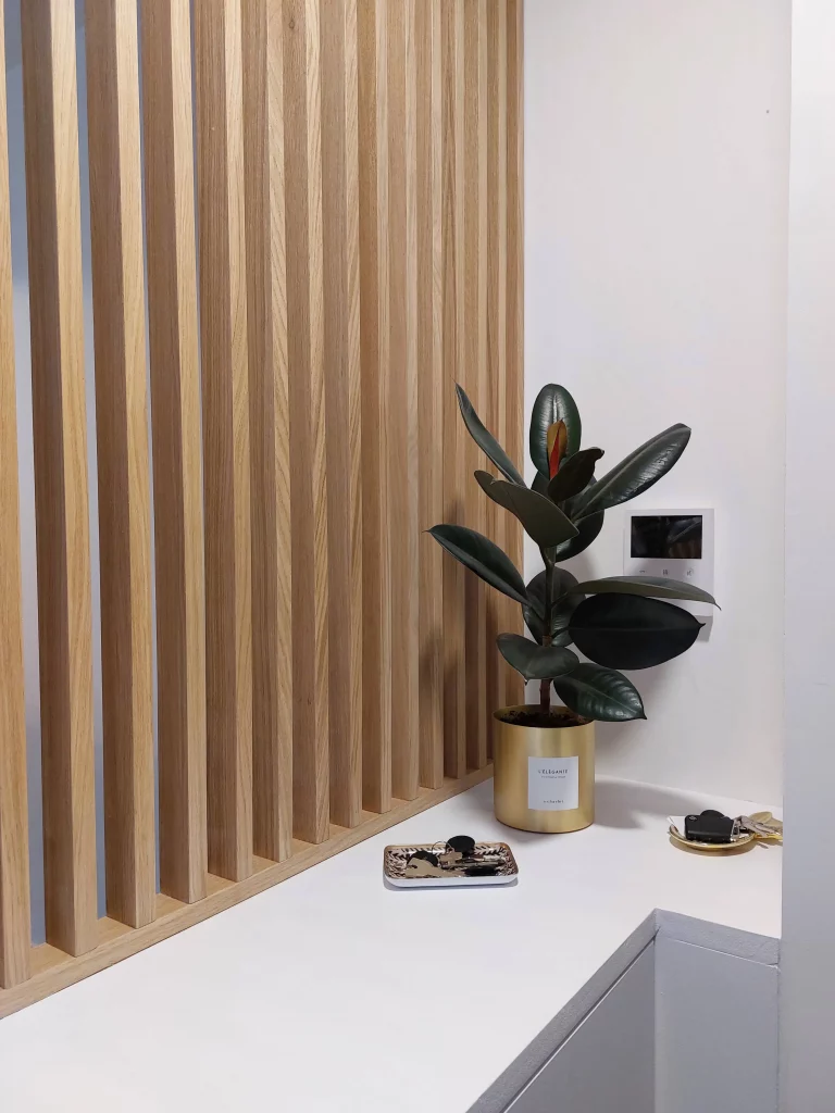 Claustra avec niche décorative en chêne dans une salle à manger dans le cadre de l'aménagement sur mesure d'une maison par une architecte d'intérieur dans les Hauts-de-Seine