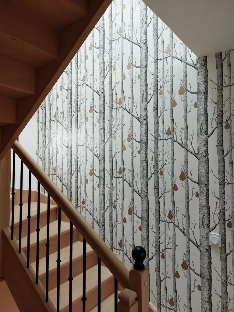 papier peint arbres posé dans une cage d'escalier avec grande hauteur sous plafond dans le 92