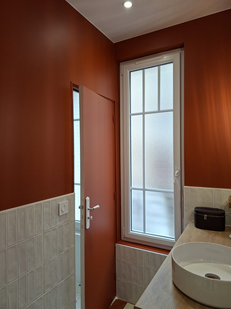 soubassement blanc cassé et mur terre battue dans une salle d'eau