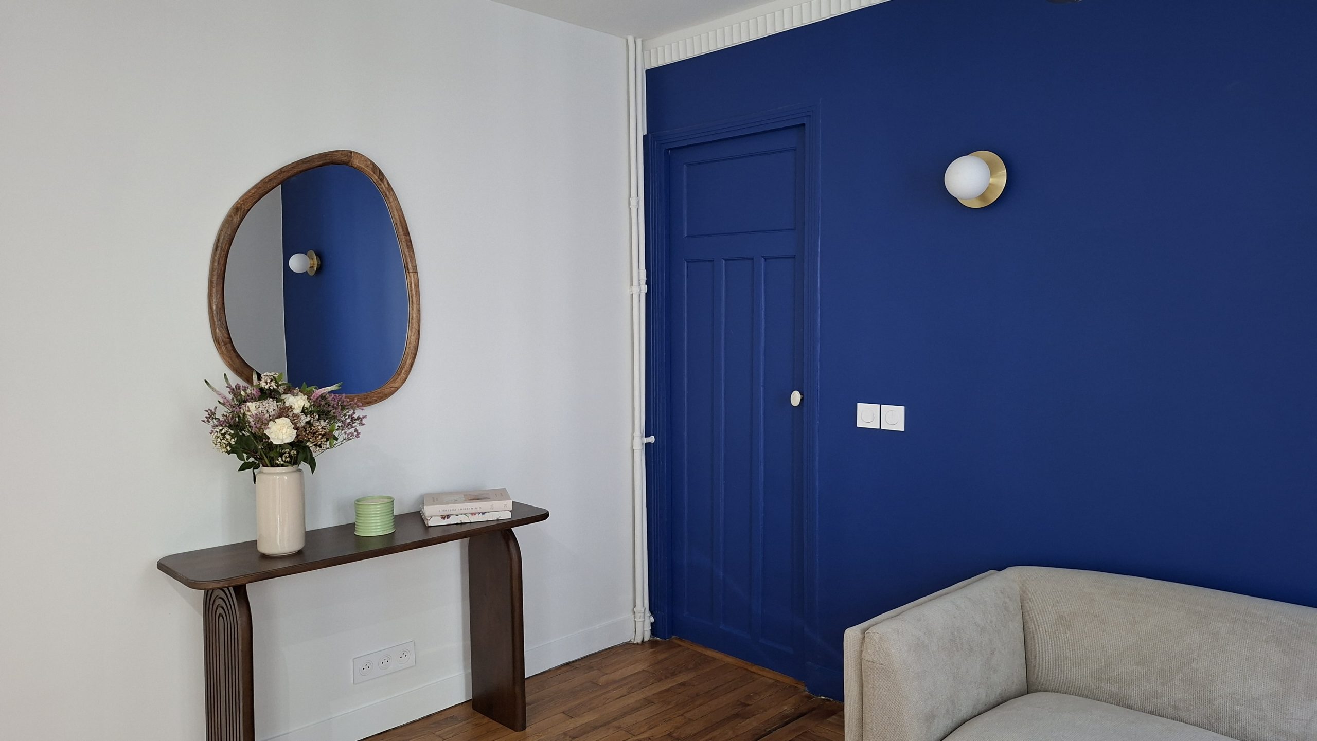 Console noyer, mur bleu et canapé écru