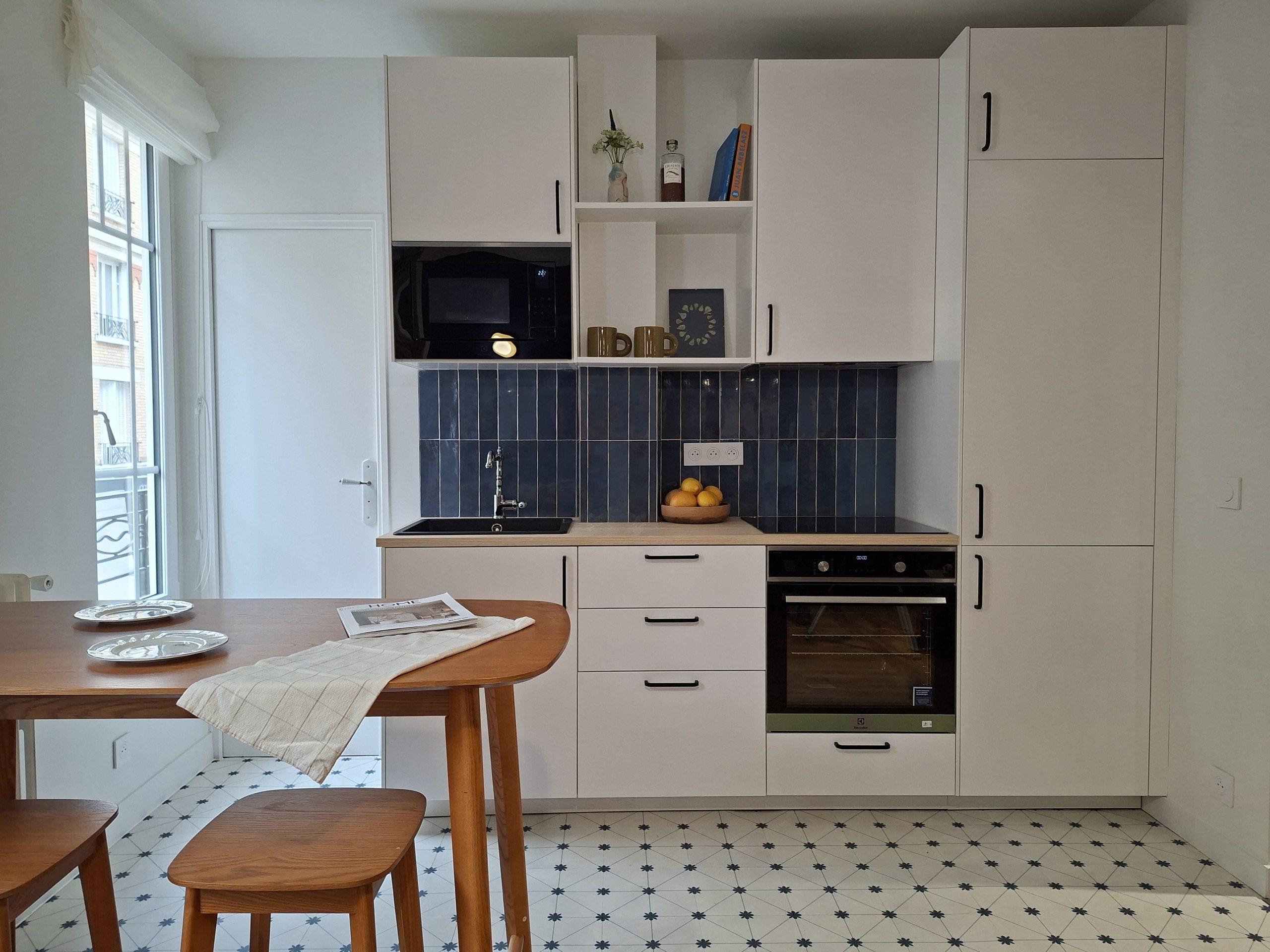 cuisine équipée blanche avec plan de travail stratifié en chêne et crédence bleue