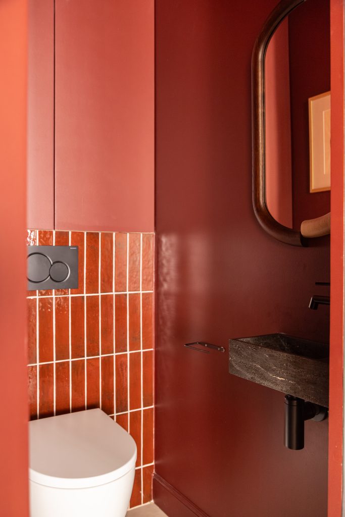 lave main et plaque de déclenchement noir dans toilettes rouge avec cuvette suspendue