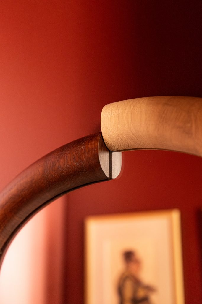 zoom sur les détails des WC rouge avec le miroir en bois reflétant une oeuvre