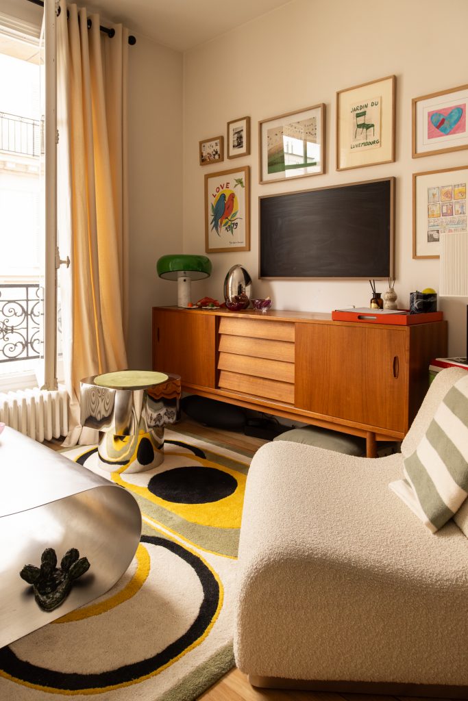 vue sur le coin séjour avec buffet vintage, TV murale et fauteuil modulable clair